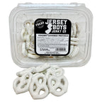 Jersey Boys Jerky yogurt covered salted pretzels in a clear plastic container with a pile of pretzels in front